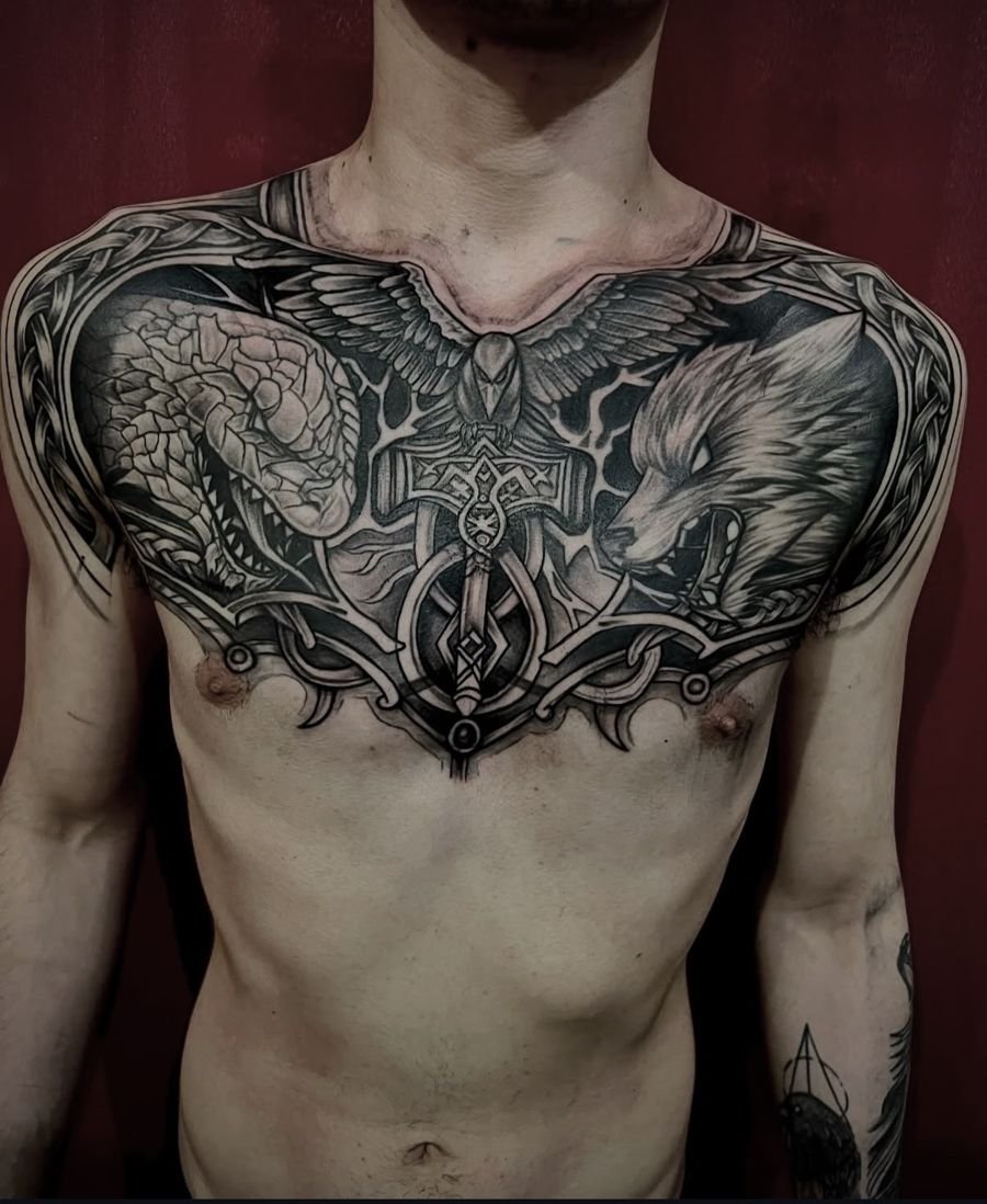 Pecho completo con serpiente, cuervo, martillo y lobo, tatuado en Estudio Bless